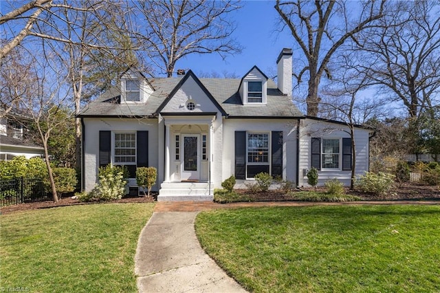 view of front of home with a chimney, a front lawn, and fence