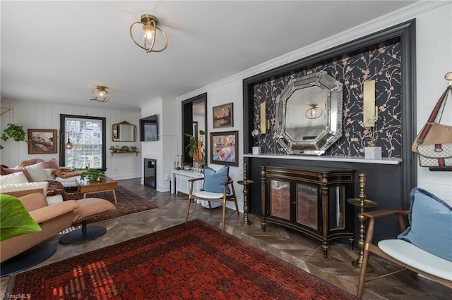 living room featuring a glass covered fireplace and crown molding