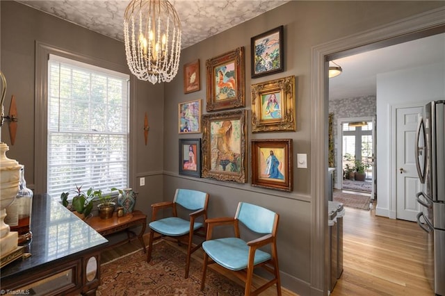 sitting room featuring light wood-type flooring and an inviting chandelier