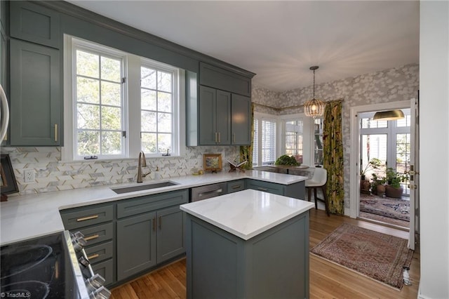 kitchen featuring a sink, a peninsula, plenty of natural light, and gray cabinetry