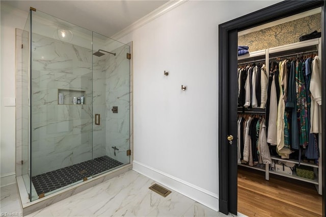 bathroom featuring baseboards, visible vents, ornamental molding, a walk in closet, and marble finish floor