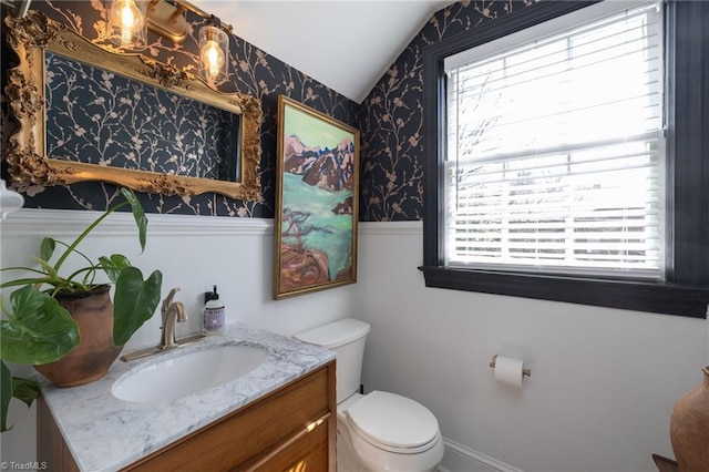 bathroom with plenty of natural light, toilet, vanity, and wallpapered walls