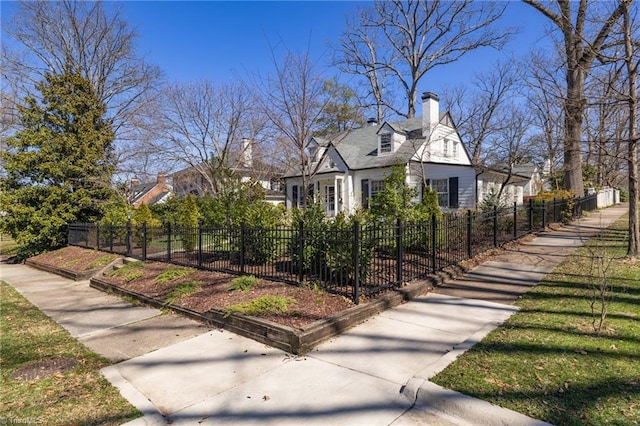 view of property exterior with a fenced front yard and a chimney