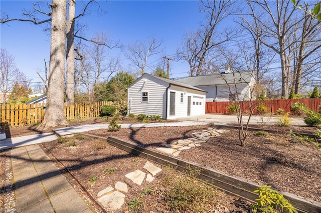 exterior space featuring a garage, an outdoor structure, and fence private yard