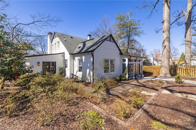 view of side of home featuring fence and a chimney