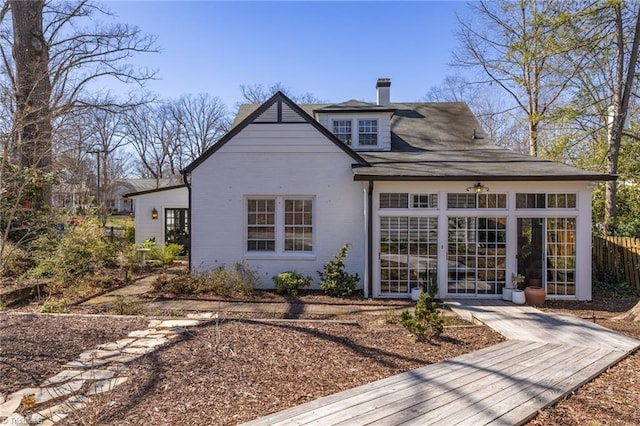 back of property featuring brick siding and a chimney