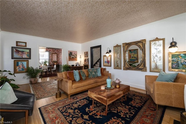 living room with a textured ceiling, crown molding, baseboards, and hardwood / wood-style flooring