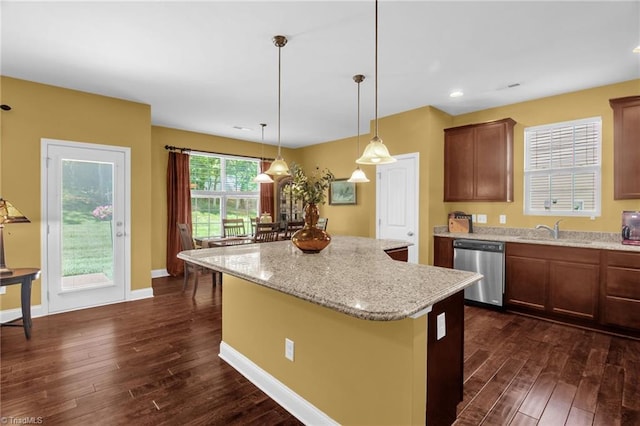 kitchen featuring dark wood-style flooring, a center island, stainless steel dishwasher, light stone countertops, and a sink