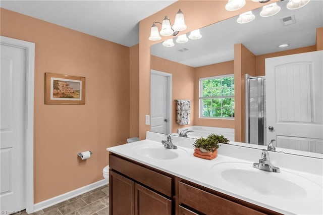 full bath featuring double vanity, baseboards, a shower stall, and a sink