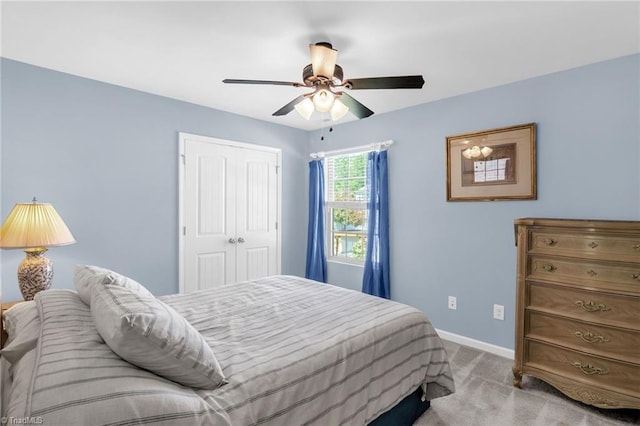 bedroom with a closet, baseboards, a ceiling fan, and carpet flooring