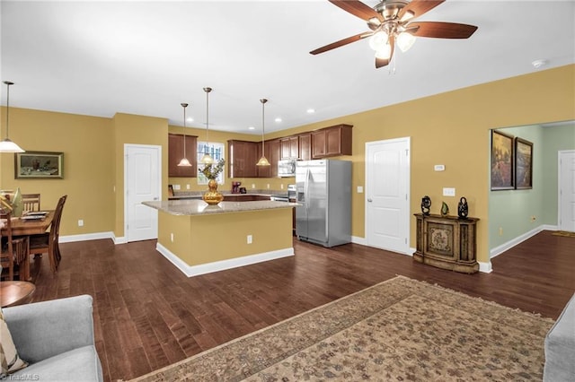 kitchen with open floor plan, dark wood-style flooring, a ceiling fan, and stainless steel appliances