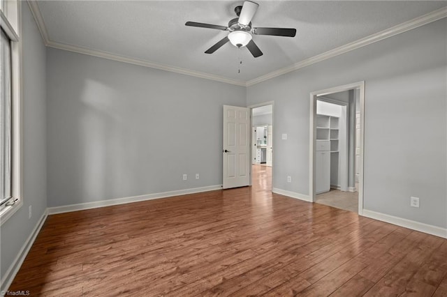 empty room featuring ceiling fan, light hardwood / wood-style floors, and crown molding