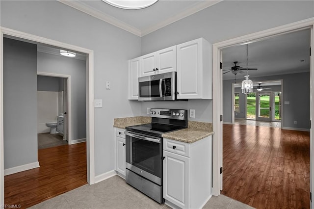 kitchen with white cabinetry, ceiling fan, stainless steel appliances, crown molding, and light hardwood / wood-style floors