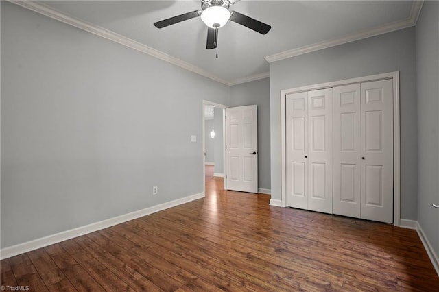 unfurnished bedroom featuring a closet, ceiling fan, dark hardwood / wood-style flooring, and ornamental molding