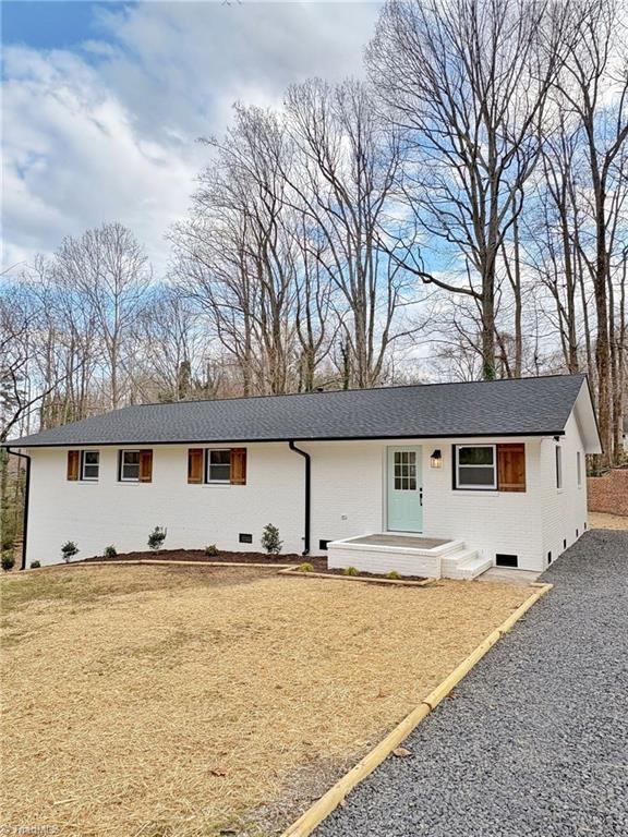 single story home with a shingled roof, crawl space, and brick siding