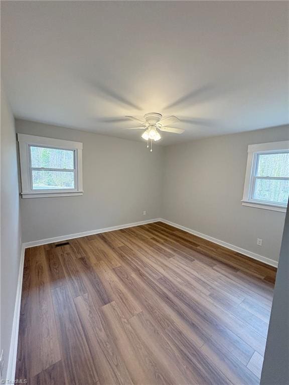 spare room with a ceiling fan, baseboards, and wood finished floors