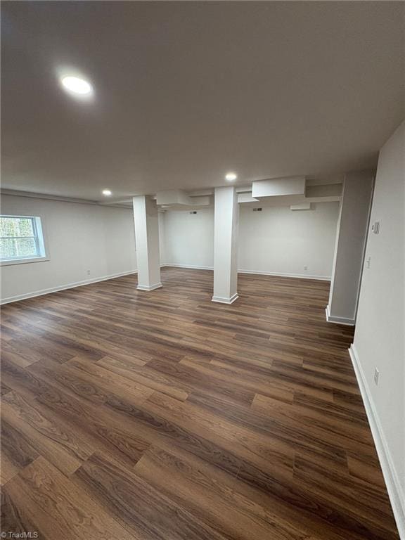 basement featuring dark wood-type flooring, recessed lighting, and baseboards