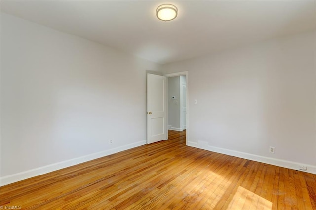 empty room with light wood-style flooring and baseboards