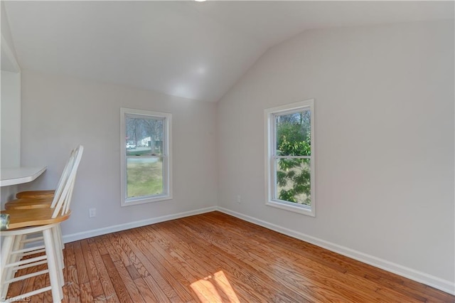 interior space with vaulted ceiling, baseboards, and wood-type flooring