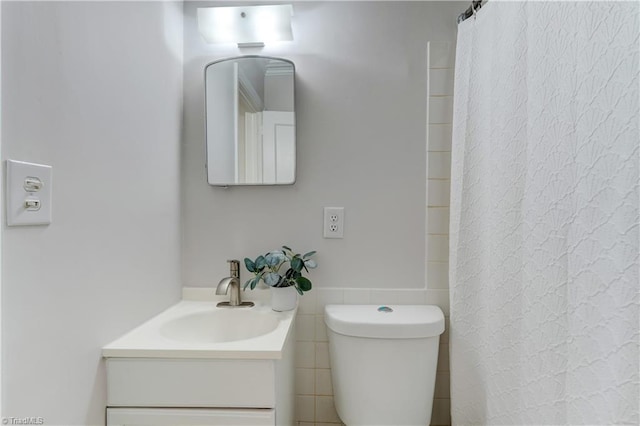 bathroom featuring curtained shower, toilet, and vanity