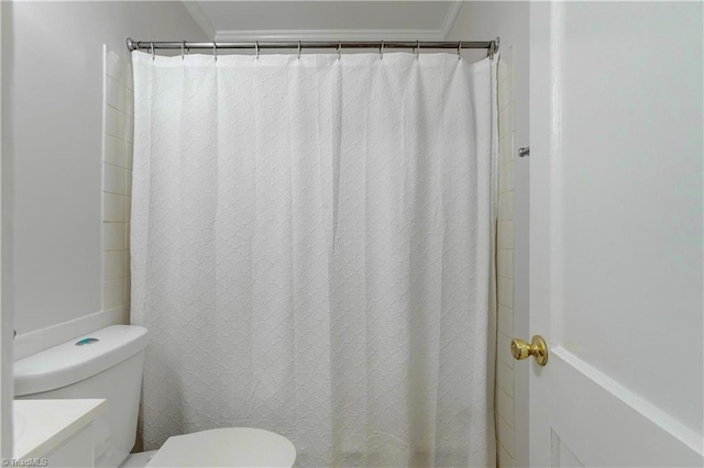 full bath featuring curtained shower, toilet, and ornamental molding