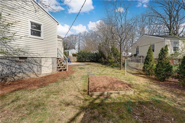 view of yard featuring a garden, stairs, and fence