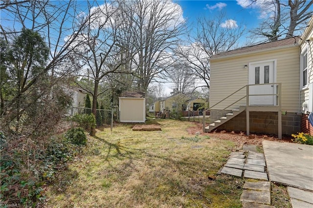 view of yard featuring french doors, an outbuilding, a shed, and fence