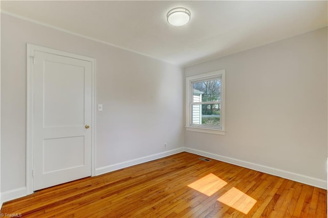 unfurnished room featuring visible vents, baseboards, and light wood-style flooring