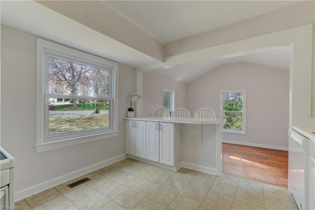 interior space with visible vents, white cabinetry, baseboards, and white dishwasher