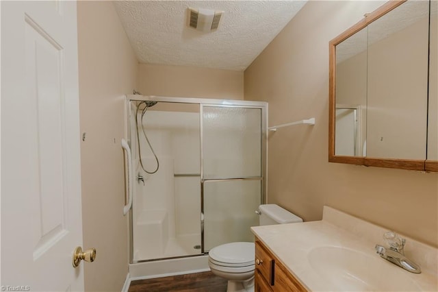 full bathroom featuring a textured ceiling, toilet, a shower stall, and visible vents