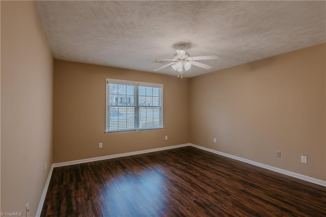 spare room with dark wood-style floors, a textured ceiling, baseboards, and a ceiling fan