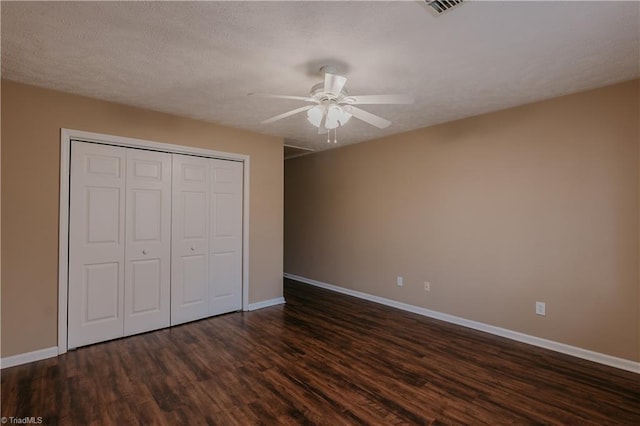 unfurnished bedroom featuring dark wood-style floors, a closet, a ceiling fan, a textured ceiling, and baseboards