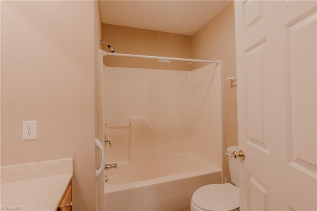 bathroom with toilet, vanity, a textured ceiling, and shower / bathing tub combination