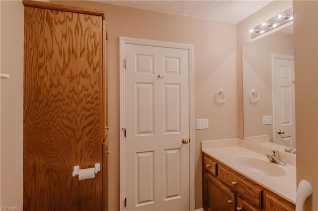 bathroom featuring a textured ceiling and vanity