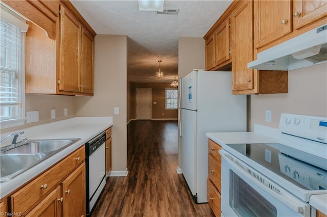 kitchen with light countertops, white appliances, a sink, and under cabinet range hood