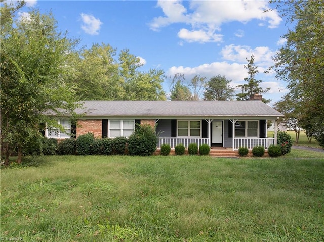 ranch-style house featuring a front lawn and covered porch