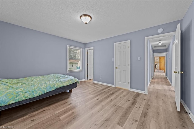 bedroom featuring light hardwood / wood-style flooring and a textured ceiling