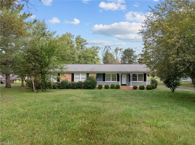 ranch-style home featuring a front lawn and covered porch