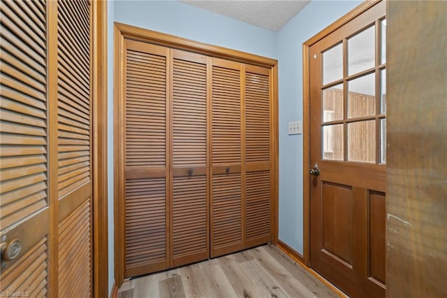 entryway featuring light hardwood / wood-style flooring and a textured ceiling