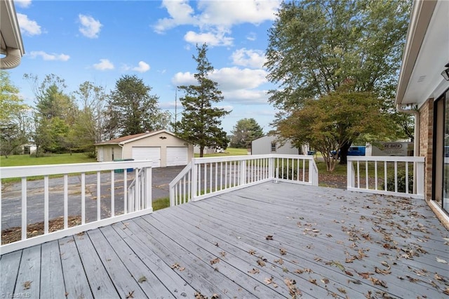 wooden terrace with a garage and an outbuilding