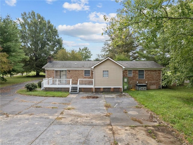 rear view of house with a lawn and a wooden deck