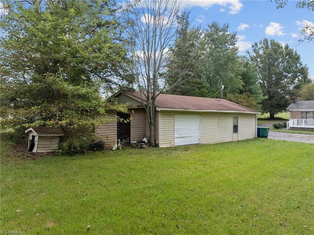 exterior space with a yard, an outdoor structure, and a garage