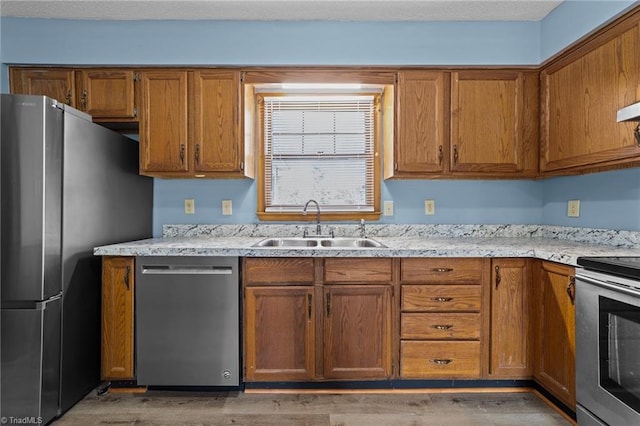 kitchen with stainless steel appliances, light wood-type flooring, and sink