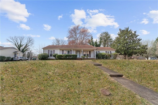 ranch-style house featuring covered porch and a front lawn