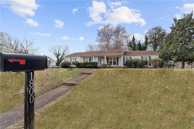 ranch-style house featuring a porch and a front lawn