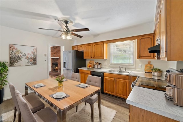 kitchen featuring dishwasher, stainless steel refrigerator with ice dispenser, brown cabinetry, a ceiling fan, and a sink