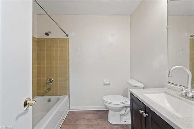 full bathroom with toilet, wood finished floors, washtub / shower combination, baseboards, and vanity