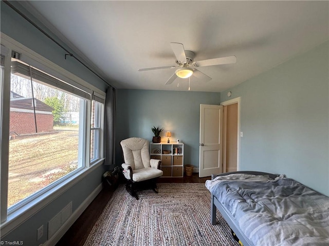 bedroom with ceiling fan, baseboards, and dark wood-type flooring