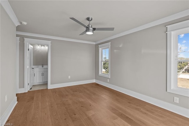 unfurnished bedroom with baseboards, ornamental molding, connected bathroom, ceiling fan, and wood finished floors