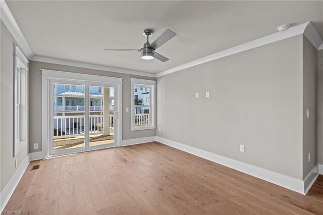 empty room featuring visible vents, baseboards, a ceiling fan, and wood finished floors
